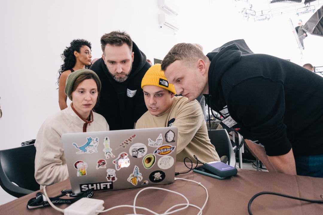 Team reviewing footage at a laptop on set
